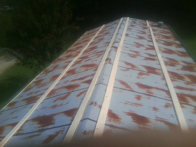 Rusted metal roof panels with new wood purlins before replacement — Storm Damage Roof Repair in Bryceville by Roofing Brothers