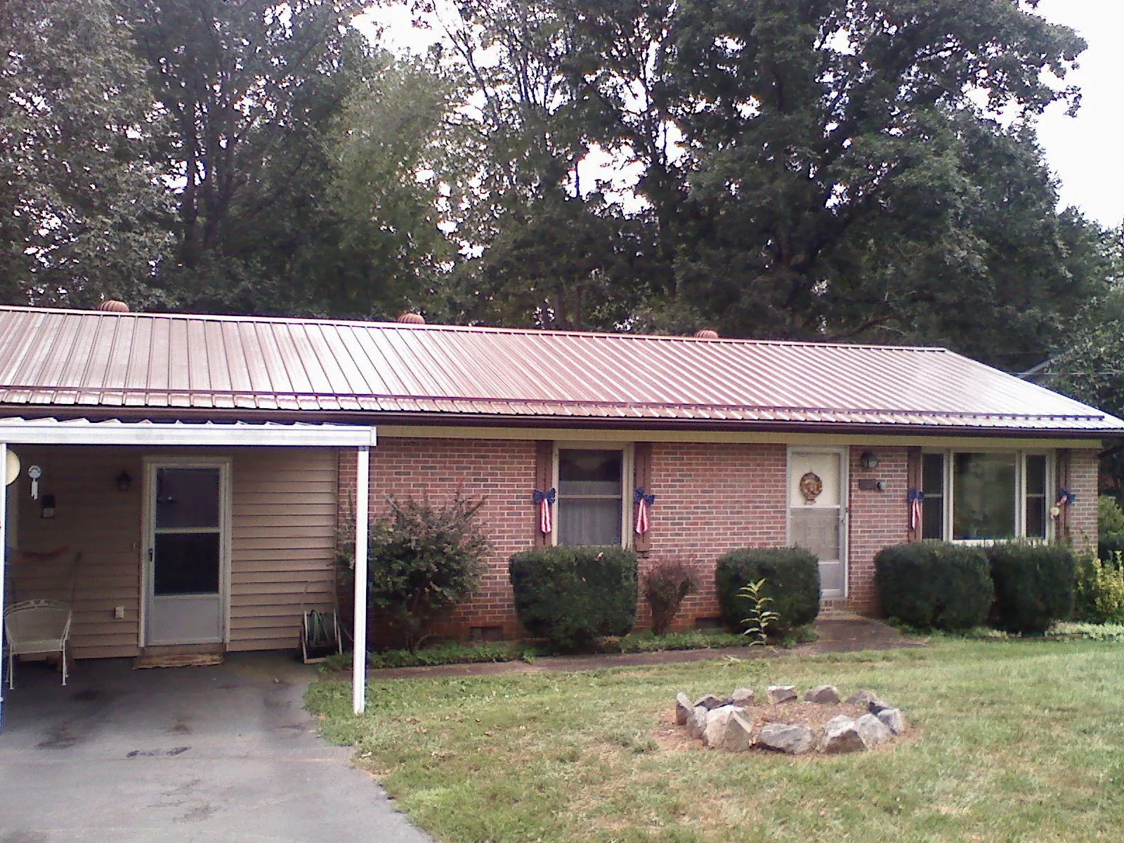 Bronze metal roof and carport on a brick ranch home — Roof Repair work by our crew in Bryceville